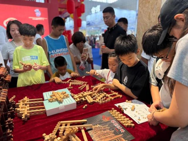 第七届山西文化产业博览交易会上，游客体验榫卯积木拼搭。（资料图）新华网 王梦佳 摄