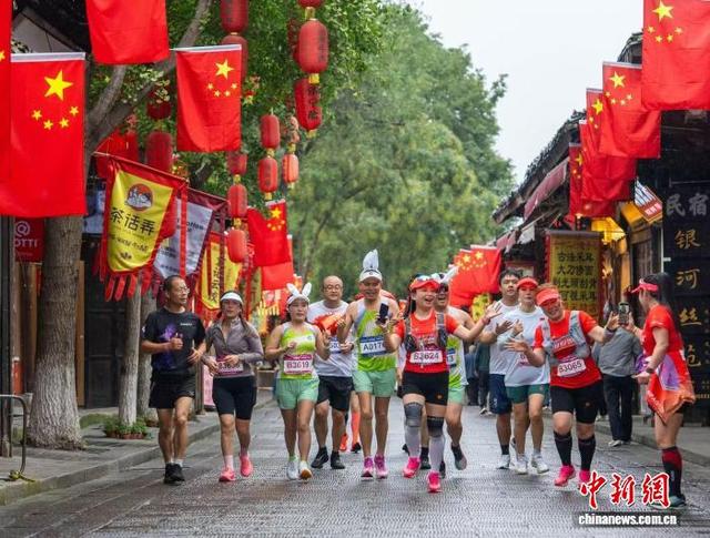 跑者在阆中古城街区与游客互动。任冠金 摄