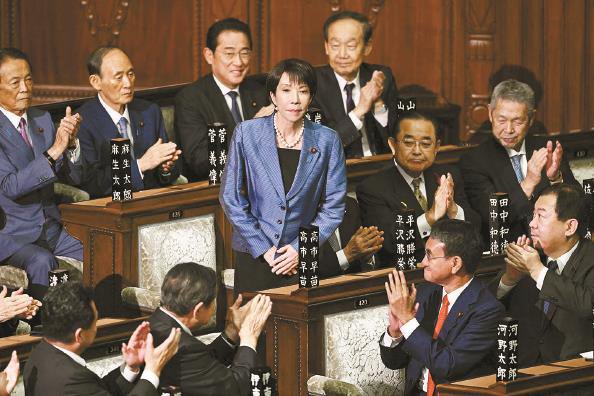 日本自民党总裁高市早苗（中）在首相指名选举中胜出后起身致谢 新华社 发