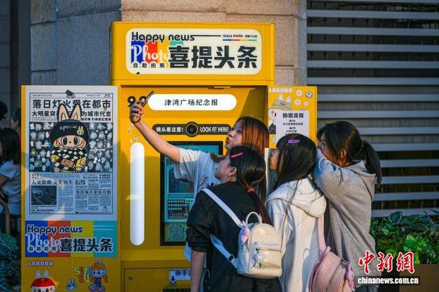 9月30日，天津津湾广场一处“拍报机”互动装置吸引众多市民游客驻足体验。中新社记者 佟郁 摄