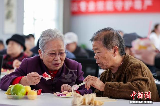 10月28日,青海西宁,生活在青海省养老服务中心的老人与幼儿园小朋友共度重阳节。图为老人品尝节日蛋糕。中新社记者 薛蒂 摄
