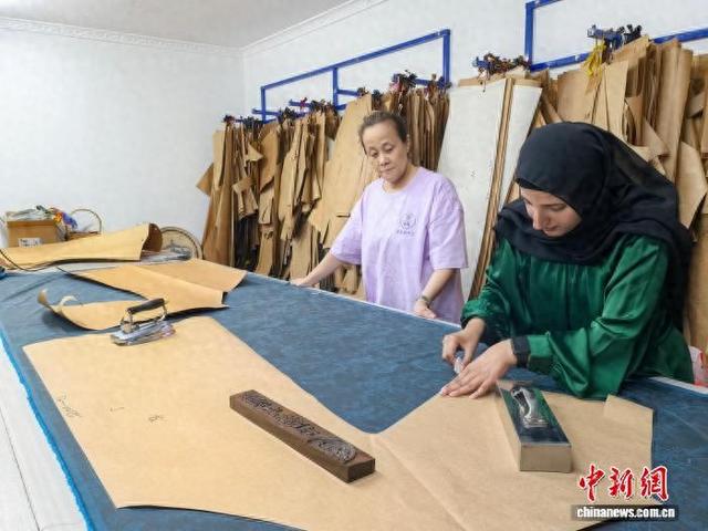 谭洁(右一)正在学习裁剪。 石洪宇 摄