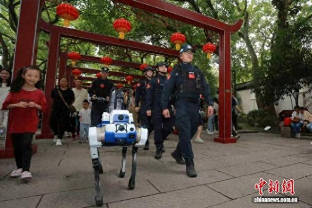 10月5日，警用巡逻防控型机器狗与民警一起在南浔古镇巡逻。南浔公安供图