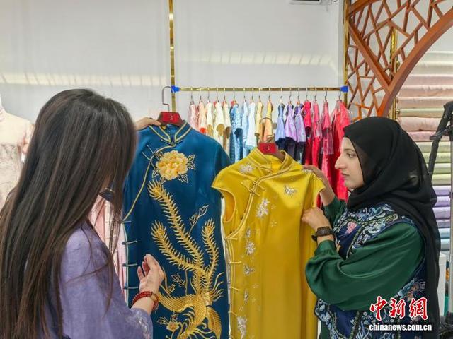 谭洁(右一)正在欣赏中国服饰。 石洪宇 摄