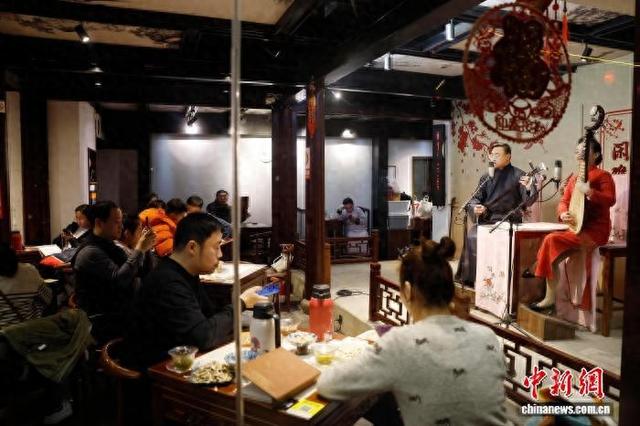 2025年2月，游客在苏州平江路历史文化街区中听评弹。 中新社记者 殷立勤 摄