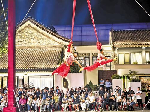 10月2日晚，游客在河头老街景区观赏杂技表演。 本报记者王育民摄