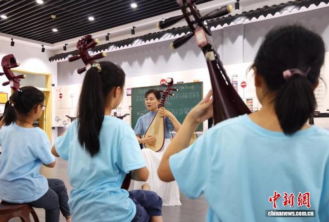 2021年10月8日，苏州市一小学的学生在老师的指导下弹奏评弹。 中新社记者 泱波 摄